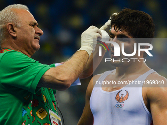 Ikhtiyor Navruzov of Uzbekistan is getting a medical help during a fight against Mostafa Hosseinkhani of Iran in the Mens Freestyle Wrestlin...