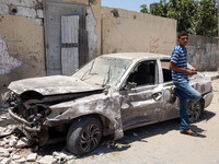 A Palestinian boy standing next to a destroyed vehicle in front of Abu Hussein school in Gaza bombed today by an Israeli tank and where at l...
