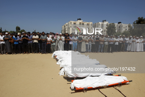 Palestinian mourners pray in front of the bodies of ten members of the al-Astal family, that were killed in an Israeli air strike on their h...