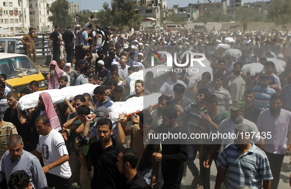 Palestinian mourners carry the bodies of the ten members of the al-Astal family, that were killed in an Israeli air strike on their homes, d...