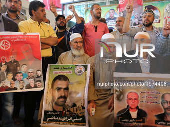 Men hold posters of Palestinian prisoners who are held in Israeli jails, during a demonstration in support of the Palestinian prisoners, out...