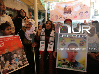 A woman holds a poster of a Palestinian prisoner who is held in Israeli jails, during a demonstration in support of the Palestinian prisoner...