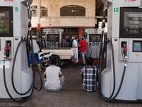 Palestinian man seating down next to empty gas pumps in the centre of Gaza (