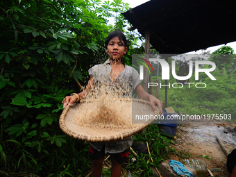 A young lady of Che Wong, Hanani husking rice to prepare lunch for her family in a rural village in Malaysia on 23 May 2017. Che Wong is one...