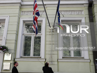 Employees of the British Embassy in Kiev, Ukraine fly a flag at half-mast, Tuesday, May 23, 2017. An apparent suicide bomber attacked an Ari...