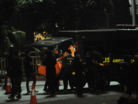 Police officers carry a body bag containing body parts from the site where a suspected suicide bombing occurred in Jakarta, Indonesia, Thurs...