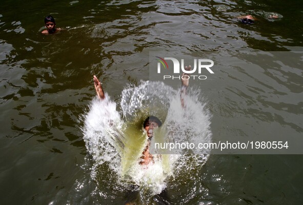 Local boys jumps into the water of a pond for cool to beat the heat the afternoon in the eastern Indian state Odisha's capital city Bhubanes...