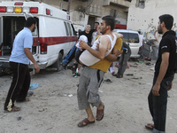 Palestinians carry a man who was wounded during an Israeli airstrike in the Shejaiya neighbourhood east of Gaza City, on 30 July 2014. Israe...