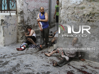 Palestinian injured men lays on the ground as he waits for help after an Israeli airstrike in the Shejaiya neighbourhood east of Gaza City,...