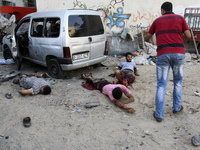 Palestinian injured men lays on the ground as he waits for help after an Israeli airstrike in the Shejaiya neighbourhood east of Gaza City,...