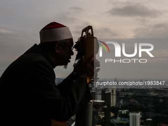 An officer of Malaysia's Islamic authority uses a telescope to perform 'rukyah', the sighting of the new moon of Ramadan, At Kuala Lumpur To...