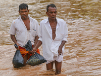Two Sri Lankan men walk across a road inundated by floods at Kaduwela 20kms away from capital city Colombo, Sri Lanka. Friday 26th  May 2017...
