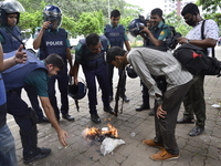 Bangladeshis policeman and journalist are gets hit from fire during a protest against the removal of a Lady Justice statue in Dhaka, Banglad...
