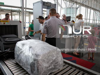 KIEV, UKRAINE - JULY 30: Security services   inspect passengers and their baggage at the Departs Entrance to Interbnational airport of Borys...