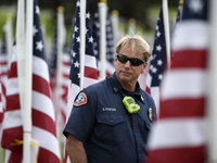 Firefighter, Ed Foster, walks through a Field of Honor graced with over 1,000 American Flags during a Memorial Day Ceremony in Forest Lawn M...