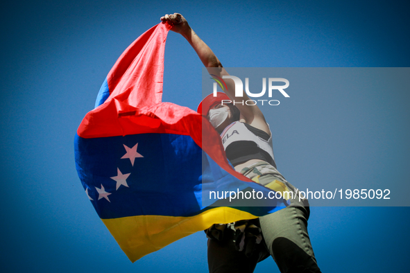 An opposition activist waves a Venezuelan national flag during clashes with the riot police during a demonstration against Venezuelan Presid...