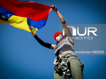 An opposition activist waves a Venezuelan national flag during clashes with the riot police during a demonstration against Venezuelan Presid...