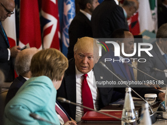 German Chancellor Angela Merkel (L) talks to U.S. President Donald Trump during the G7 Summit expanded session in Taormina, Sicily, on May 2...