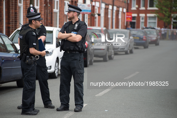 Police officers guard a cordoned street, a place where part of the investigation in to the Manchester Arena explosion is taking place, in Ma...