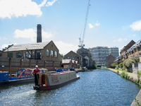 View of an iconic houseboat while sails on a sunny Saturday afternoon on Regent's Canal, London on May 27, 2017. Regent's Canal is a canal a...