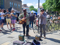 Two buskers are pictured while singing at Broadway Market, London on May 27, 2017. (