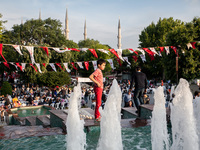 People break their fasting on 27 May, 2017 as they eat sitting on benches at the Blue Mosque square in Istanbul, during the first day of the...
