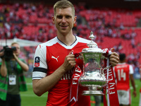Arsenal's Per Mertesacker with Trophy
during The Emirates FA Cup - Final between
Arsenal against Chelsea at Wembley Stadium
on May 27 2017 ,...