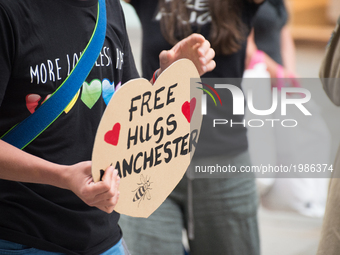 A person holds a heart-shaped placard, showing free hugs are available, for people out in central Manchester in Manchester, United Kingdom o...
