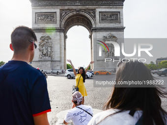 Tourists are taking selfies in front of the Triumphal Arch in Paris, France on May 28, 2017. Much of French people and tourists enjoyed hot...