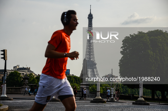 A man running in front of the Eiffel Tower in Paris, France on May 28, 2017. Much of French people and tourists enjoyed hot and sunny weathe...