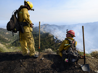 Firefighters watch a wildfire burning in Mandeville Canyon in Los Angeles, California on May 28, 2017. More than 150 firefighters battle the...