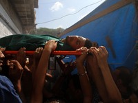 Palestinian mourners carry the body of Mohammed al-Daeri, 25, during his funeral in Gaza City on July 31, 2014. At least 10 people were kill...