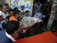 A Rescue teams pulling out the body of a Palestinian woman from a home after it was hit by an Israeli air strike in Rafah, the southern Gaza...