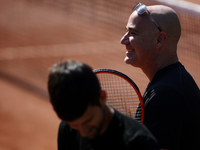 Coach Andre Agassi smiles during a Novak Djokovic training session prior to his match against Marcel Granollers of Spain on day two of the 2...