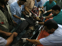 A Palestinian medics wheel a man body into the al-Najar hospital in Rafah, southern Gaza Strip, on July 31, 2014. At least 10 people were ki...