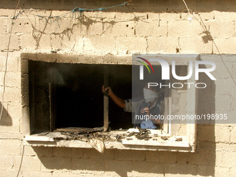 A Palestinian man tries to extinguish fire at a home after it was hit by an Israeli air strike in Rafah, the southern Gaza Strip, on July 31...