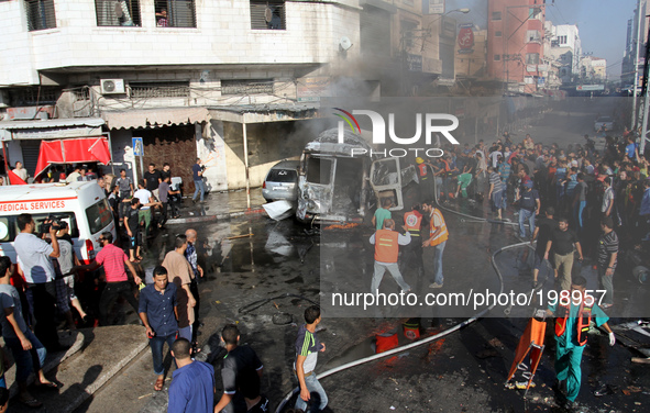 Palestinian firefighters try to put out the fire in a van after an Israeli air strike, in Gaza City, on 31 July 2014. 
