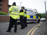 Police officers guard a cordoned off street, a place where part of the investigation in to the Manchester Arena explosion is taking place, i...