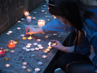 A person lights candles, as a tribute for the victims of the Manchester Arena attack, in Manchester, United Kingdom, Monday, May 29, 2017. G...