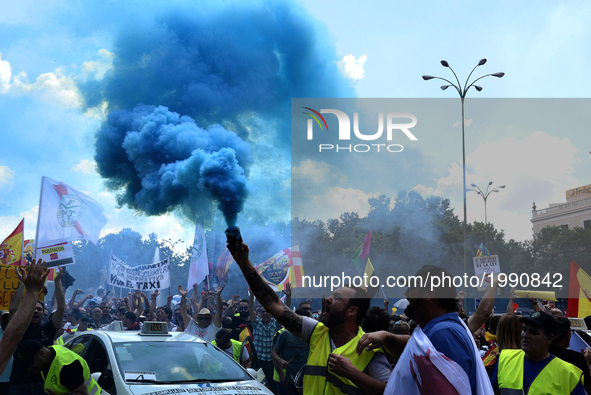 People holding smoke bombs march during a protest by a Spanish taxi drivers in Madrid on 30 th May, 2017. 