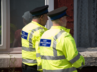 Police Community Support Officers speak to a person on the street where part of the investigation in to the Manchester Arena explosion is ta...