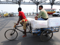 An Indian labourer uses a rickshaw transport material cross the howrah bridge in  Kolkata on June 1, 2017.  India's economic growth slowed t...