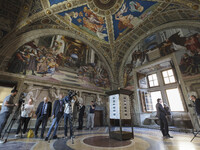 Visitors attend the inauguration of a new type of lighting from OSRAM in the Raphael’s Rooms at the Vatican Museums on June 01, 2017. The Ra...