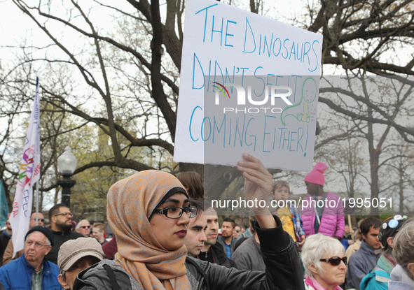 Demonstrator holds a sign saying 'the dinosaurs didn't see it coming either' as hundreds of Canadians took part in a massive march against c...
