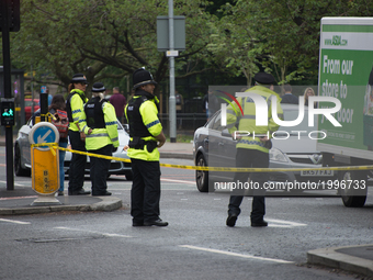 Police officers guard the cordoned off area of a street, where part of the investigation in to the Manchester Arena explosion is taking plac...