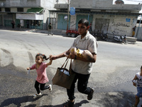 Palestinian families flee their homes in Rafah, in the southern Gaza Strip, to a safer location following Israeli military strikes on their...