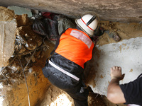 A Palestinian rescue workers dig out the body of a man from the rubble of his home following an Israeli military strike on Rafah, in the sou...
