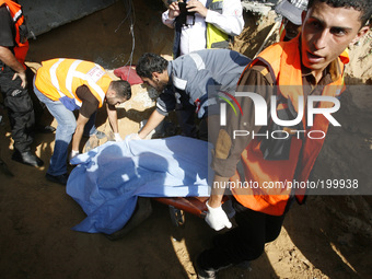 A Palestinian rescue workers dig out the body of a man from the rubble of his home following an Israeli military strike on Rafah, in the sou...