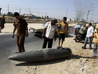 Palestinians look at an unexploded Israeli shell that landed on the side of a road in Deir al-Balah, central Gaza Strip, on 01 August 2014....