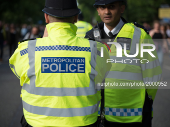 Police officers patrol as people arrive for the One Love Manchester benefit concert at the Old Trafford cricket ground in Trafford, United K...